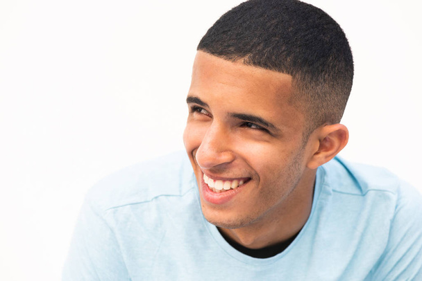 De cerca retrato de feliz sonriente joven hombre del norte de África mirando hacia otro lado por el fondo blanco
 - Foto, Imagen
