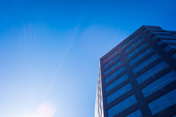 Blue sky gradient background next to a business office building. - 写真・画像