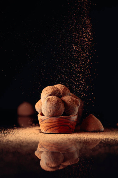 Truffes au chocolat dans un petit plat en bois saupoudré de cacao
 - Photo, image