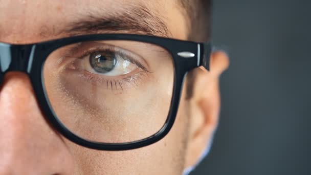 Μάκρο μάτι ανθρώπου με γυαλιά. Κοντινό μάτι του επιχειρηματία ή φοιτητής με γυαλιά - Πλάνα, βίντεο