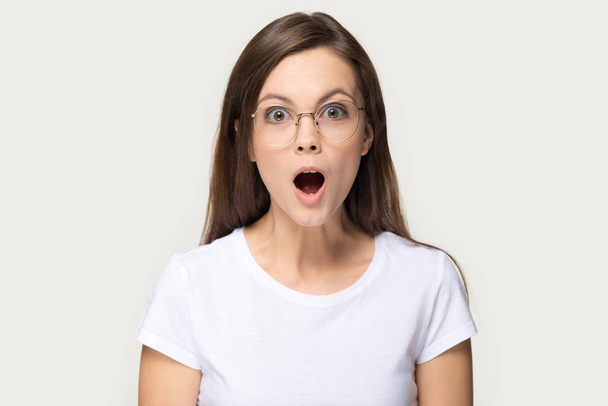 Fejlövés sokkos Y-generációs nő szemüvegben nyitott szájjal - Fotó, kép