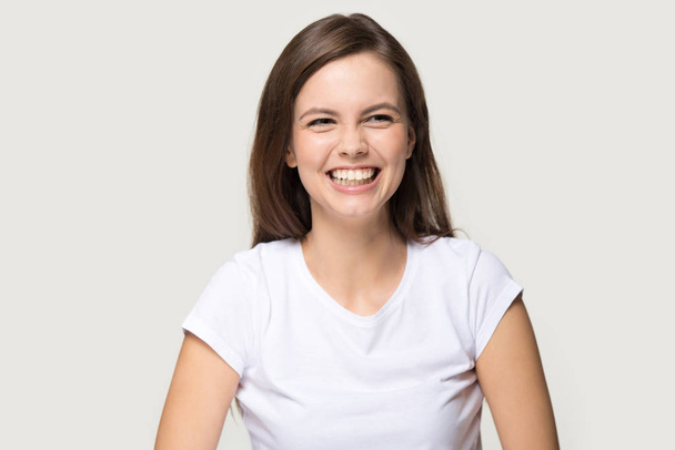 Headshot of young pretty brunette girl sincerely laughing at joke - Photo, Image