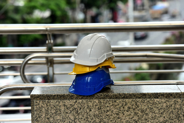 різнокольорові будівельні шоломи біля ліфта
 - Фото, зображення