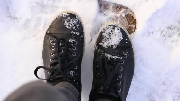 Mädchen in schwarzen Turnschuhen läuft nachmittags im Schnee nach Hause - Filmmaterial, Video