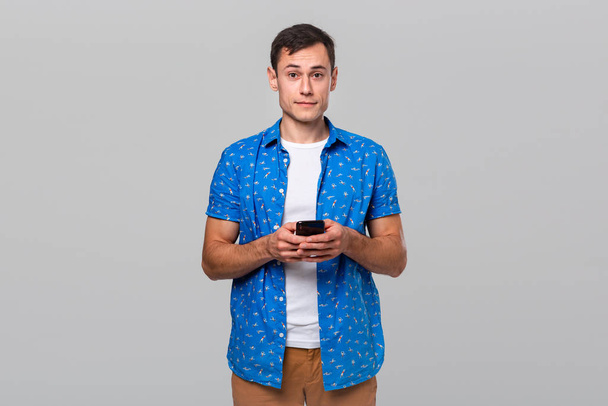 Jeune bel homme tenant smartphone vérifier les notifications d'un réseau social
. - Photo, image