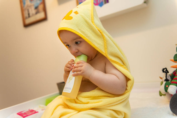 Adorabile bambina seduta sotto un asciugamano incappucciato dopo il bagno
 - Foto, immagini