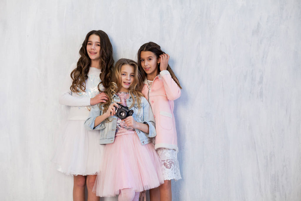 Retrato de tres hermosas chicas amigas de moda con una cámara en ropa blanca rosa
 - Foto, Imagen