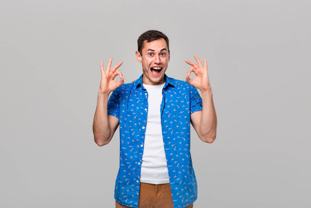 Handsome man showing OK sign with two hands smiling looking at the camera - Photo, Image