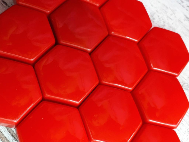 αφηρημένο κόκκινο φόντο με τη μορφή κυψελών μελισσών σε ξύλινη επιφάνεια - Φωτογραφία, εικόνα