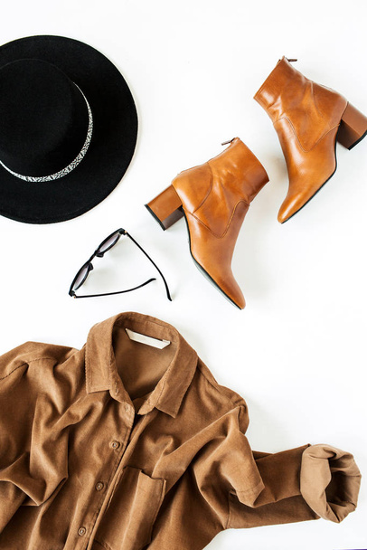 Flat lay fashion collage with women modern clothes and accessories on white background. Brown shirt, shoes, glasses, hat. Lifestyle, beauty concept for blog, social media, magazine. - Photo, Image