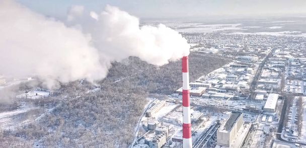 smoking chimney of a thermal power plant on the background of winter city. - Photo, Image