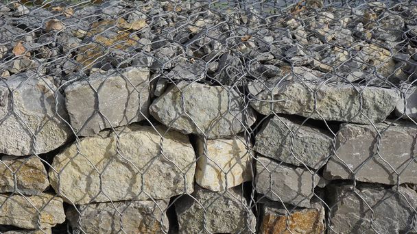 Frenos de piedra reforzados con malla que bloquean la calzada desde la acera
 - Foto, imagen