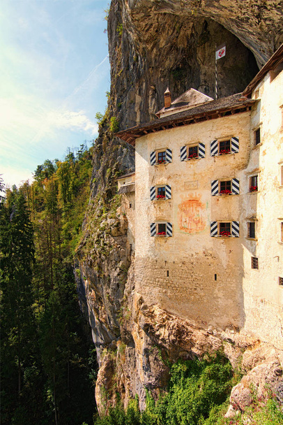 Художній пейзаж стародавнього замку Преджама (Predjamski grad). Він був побудований в печерному гирлі в південно-центральній Словенії. Знамените туристичне місце і романтична туристична доля. - Фото, зображення