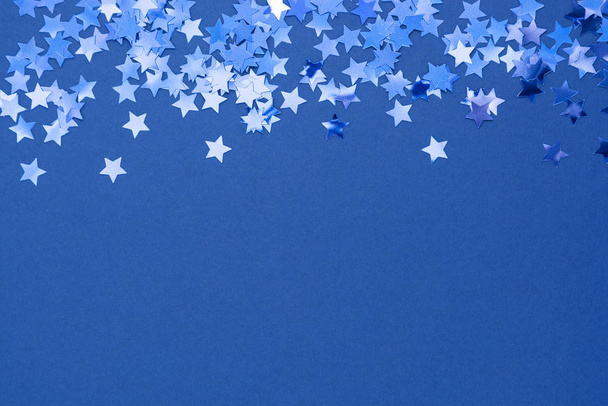 Blue abstract Christmas background or texture with stars confetti on blue background. Space for text. - Фото, зображення