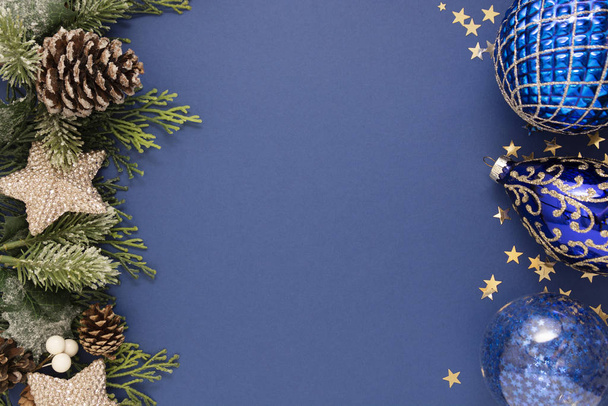 Kerst blauwe abstracte achtergrond met blauwe kerstballen en sparren takken over blauwe achtergrond. Kerst- en Nieuwjaar wintervakantie wenskaart. Minimaal concept. - Foto, afbeelding