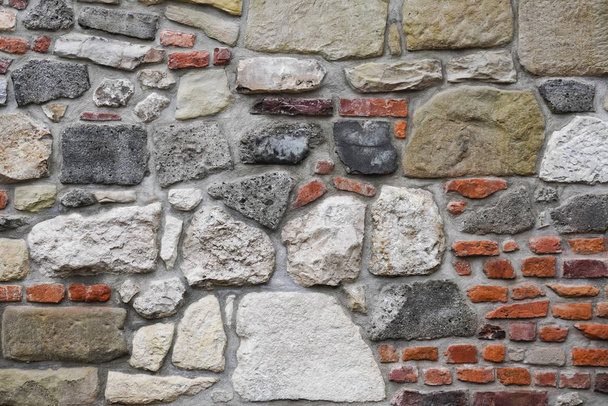 Fragment of the restoration of masonry of red old brick and big stones contrast. different size and color bricks, background, screensaver place for text, copyspace. - Photo, Image
