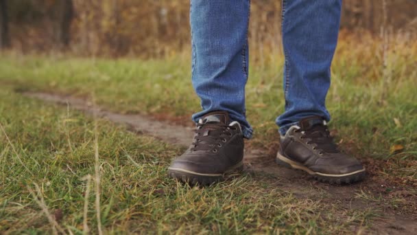 Concetto di uomo inquinamento natura. Un primo piano di un uomo irresponsabile in jeans si pulisce le scarpe con salviettine bagnate e lo getta sull'erba.
. - Filmati, video