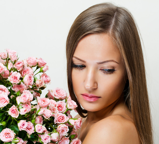 woman with beautiful face and pink flowers - Photo, Image