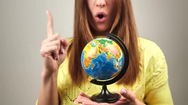 girl twists the globe and points a finger at geolocation - Footage, Video
