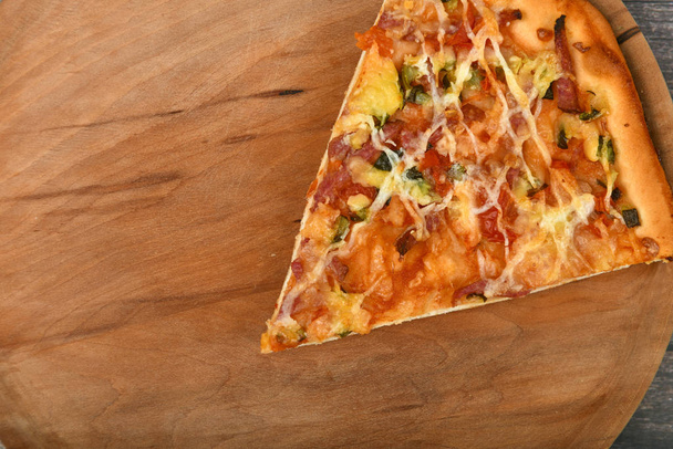 Slice of pizza on a wooden background. a slice of pizza. Top view of a slice of pizza. from an empty template. Flat lay - Photo, Image