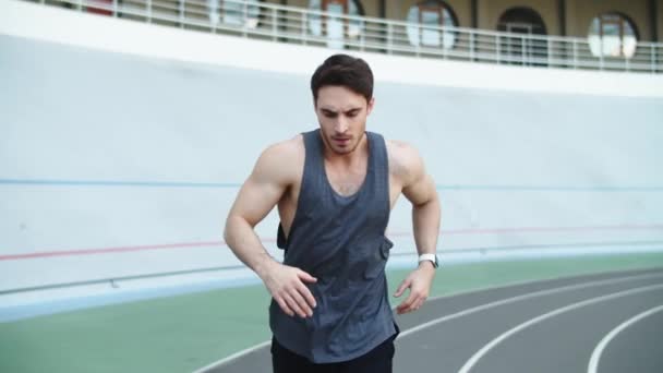 Férfi futó fut a modern pályán. Sport ember fut a versenypályán - Felvétel, videó