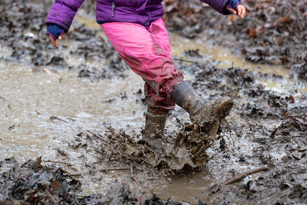 Μικρά παιδιά που παίζουν σε μια λακκούβα λάσπης - Φωτογραφία, εικόνα
