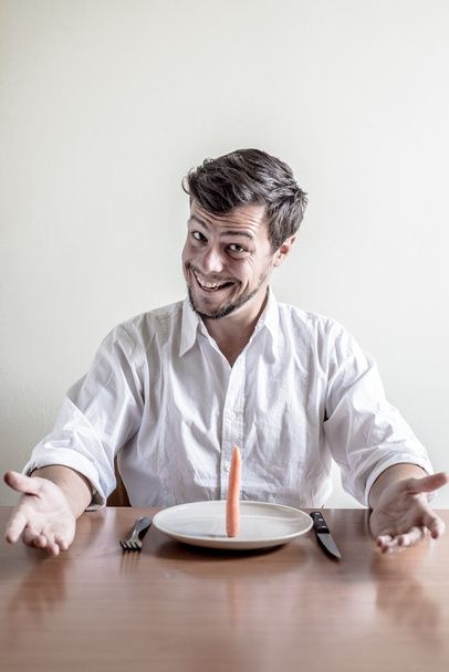 young stylish man with white shirt eating carrot - Foto, Imagen