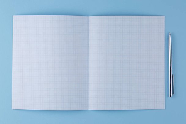 school notebook with pen on a blue table top view - Fotoğraf, Görsel
