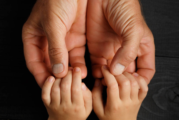 Les mains d'adulte tenant les mains d'enfant
 - Photo, image