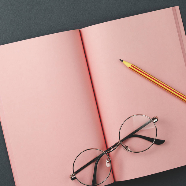 Cuaderno rosa sobre fondo gris vista superior
 - Foto, imagen