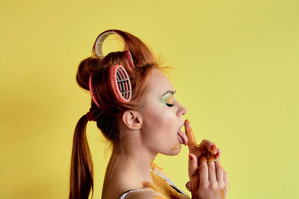Young redhead woman with shugaring paste on her hands, face, body and chest. Young redhead woman with hair curlers. Advertising concept of shugaring paste. Skin care concept with copyspace. - Fotoğraf, Görsel