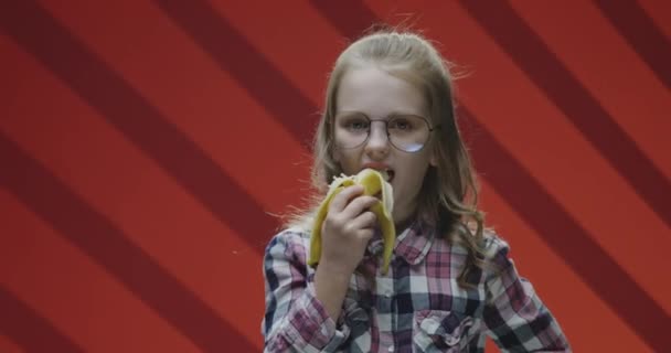 Child eating banana and complaining to camera - Footage, Video