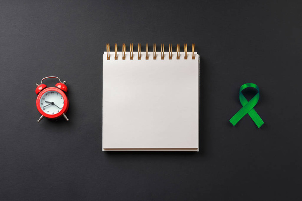 cinta de cáncer verde en el cuaderno en la mesa oscura
 - Foto, imagen