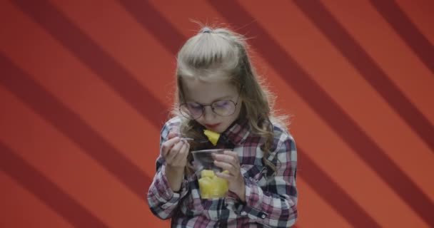 Chica comiendo piña de la taza de plástico
 - Imágenes, Vídeo