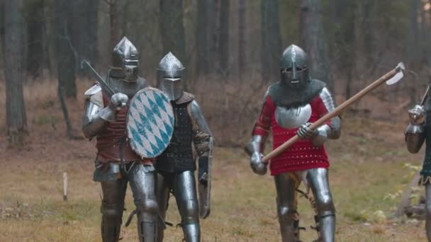 Cuatro hombres caballeros caminando en la fila en el bosque con armadura completa sosteniendo diferentes armas
 - Metraje, vídeo