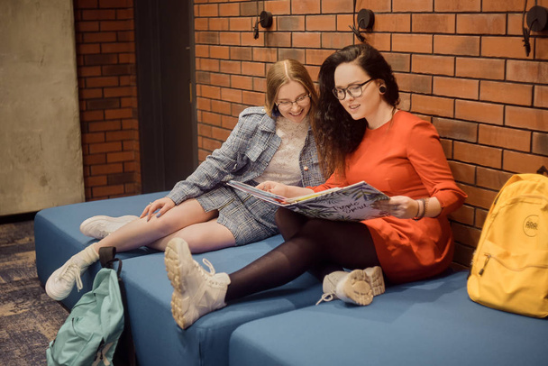 Studenti di sesso femminile siedono nel corridoio dell'università / universi
 - Foto, immagini