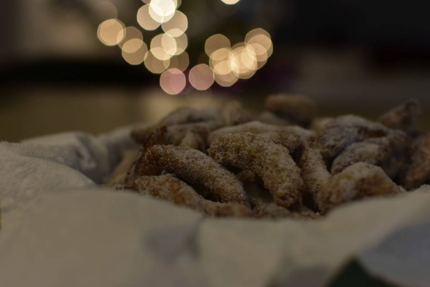 Galletas navideñas tradicionales alemanas y austriacas, semilunas de vainilla sobre plato decorado en polvo con azúcar de ricino y luces navideñas
.  - Foto, Imagen