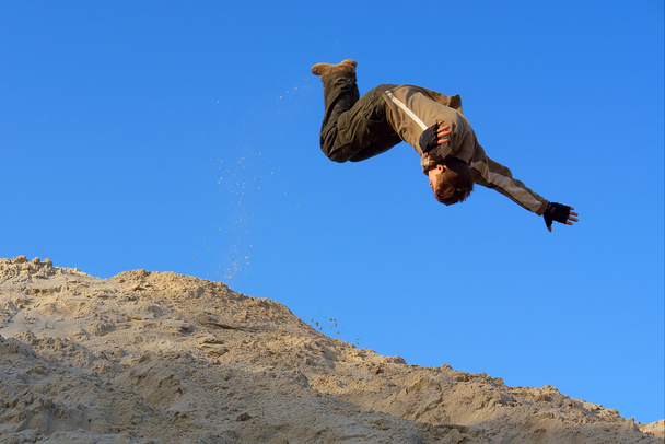 nastolatek wykonuje skok poślizg na piasek Górka - Zdjęcie, obraz