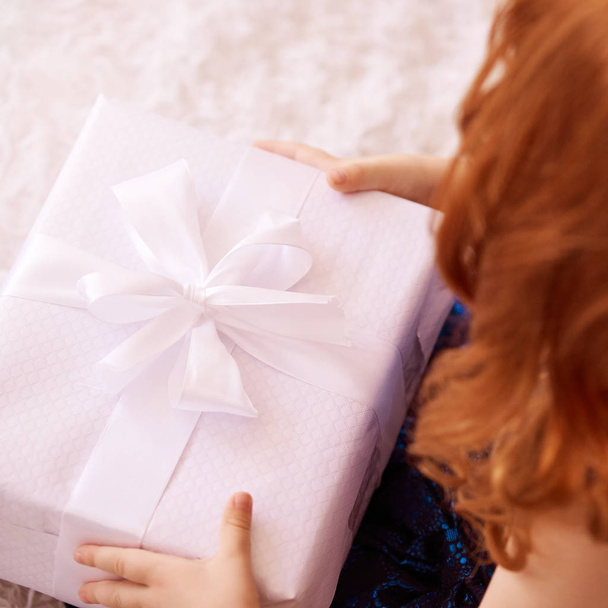 Little girl hold gift box. Red hair child smiling - Foto, Imagem