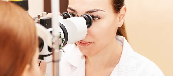 ophthalmologist doctor in exam optician laboratory with female patient. Eye care medical diagnostic. Eyelid treatment - Fotoğraf, Görsel