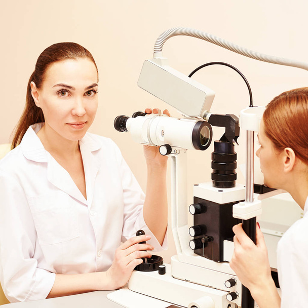 ophthalmologist doctor in exam optician laboratory with female patient. Eye care medical diagnostic. Eyelid treatment - Foto, afbeelding