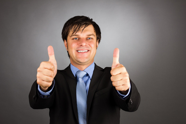 Happy young business man showing thumbs up gesture - Photo, image
