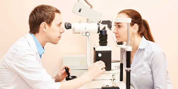 ophthalmologist doctor in exam optician laboratory with male patient. Men eye care medical diagnostic. Eyelid treatment - Foto, afbeelding