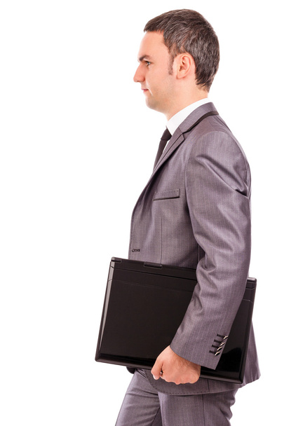 Portrait of a young businessman holding a laptop under his arm - Zdjęcie, obraz