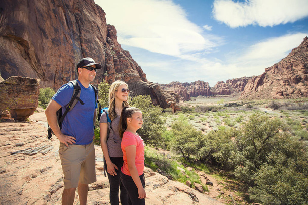 Atrakcyjna młoda rodzina z widokiem na piękny malowniczy widok w czerwonym skalistym kanionie w południowo-zachodnich Stanach Zjednoczonych. - Zdjęcie, obraz