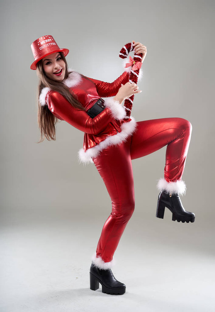 Beautiful Santa woman in red costume over gray background - Fotografie, Obrázek