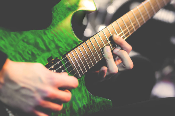 Muž hrající na kytaru. Zelená elektrická kytara - Fotografie, Obrázek