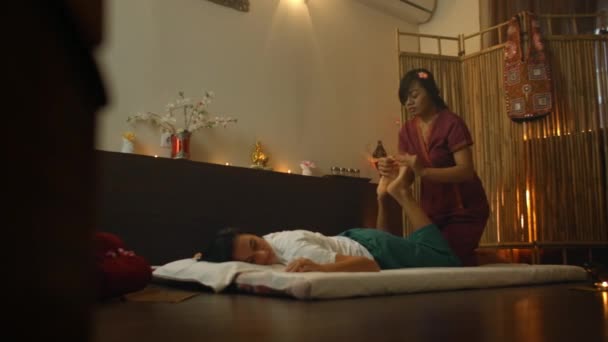 Młoda kobieta kłamliwy w dół ciesząc się technik akupresury tradycyjny masaż tajski luksusowe centrum spa i odnowy biologicznej. - Materiał filmowy, wideo