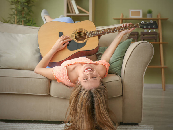 Beautiful young woman with guitar at home - Foto, Imagem