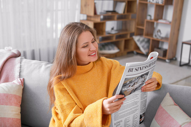 Молодая женщина читает дома газету - Фото, изображение